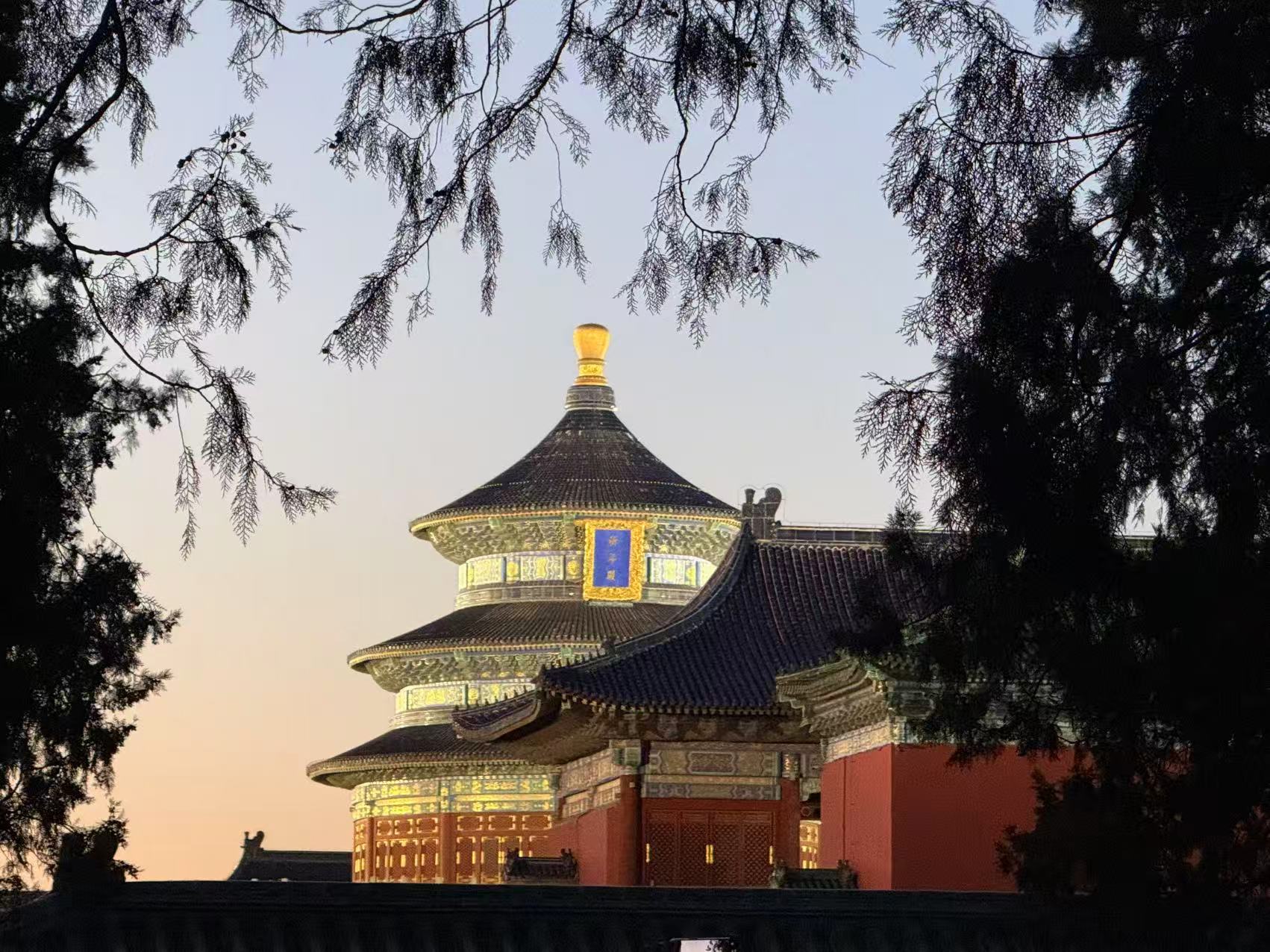 天坛傍晚,祈年殿在树影和晚霞中亮灯